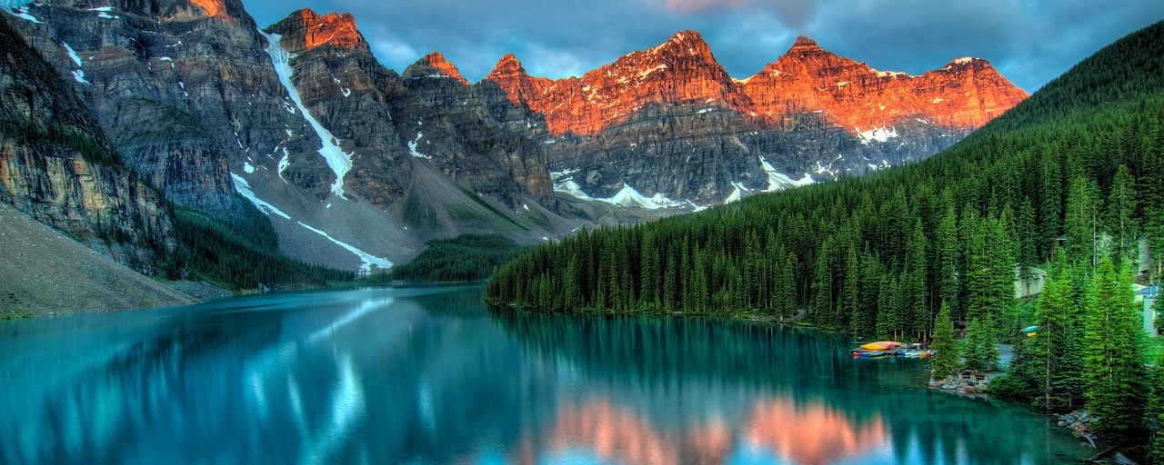 Moraine Lake beneath sunlit mountain peaks in Banff National Park, Canada.