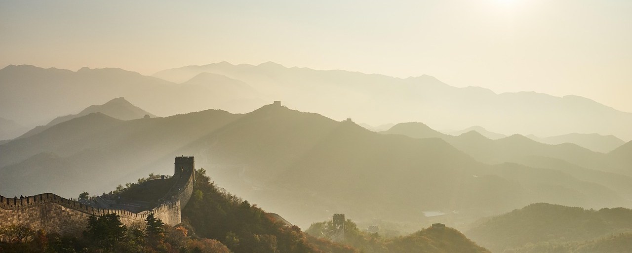Great Wall winding across mountains at sunset in China.