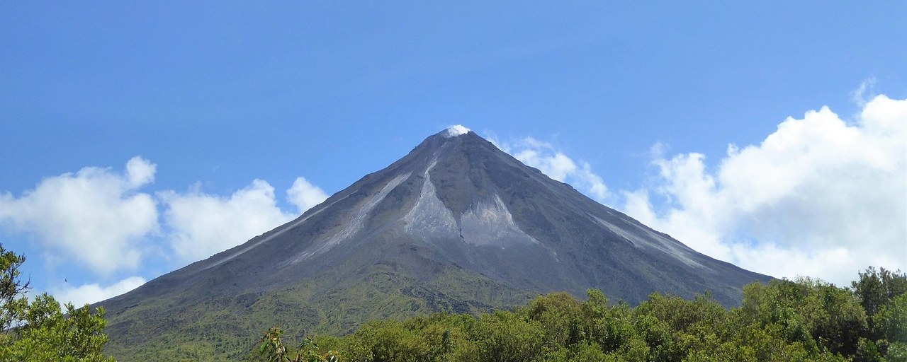 Arenal Volcano rising above green forest in Costa Rica.