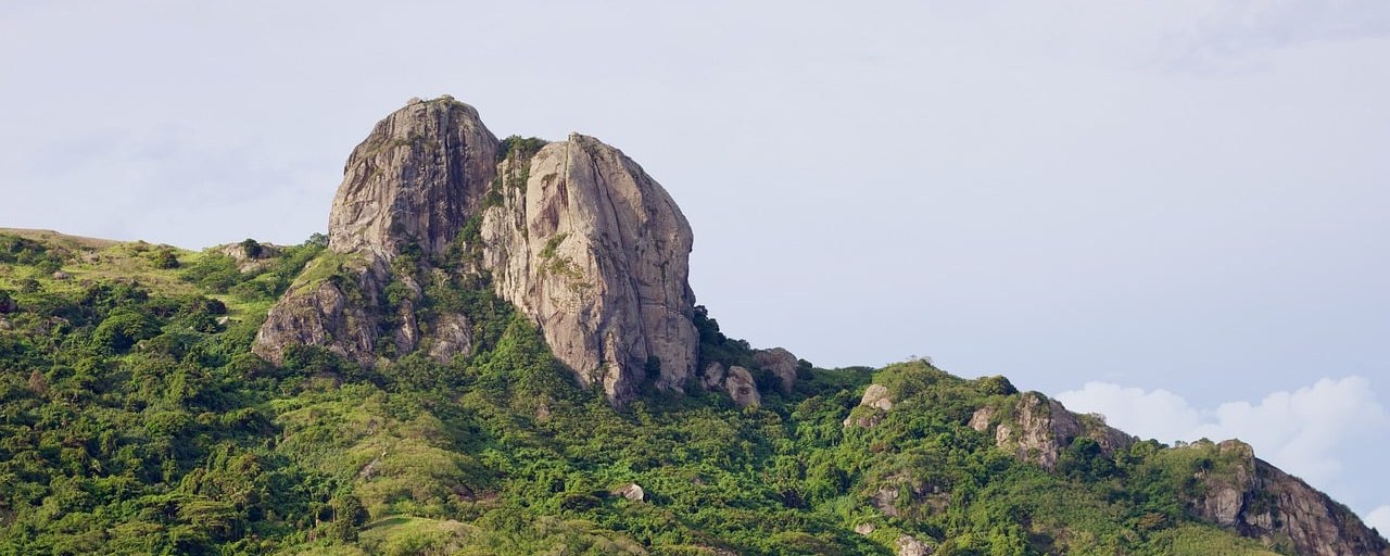 Rocky summit above forested slopes on Kuata Island, Fiji