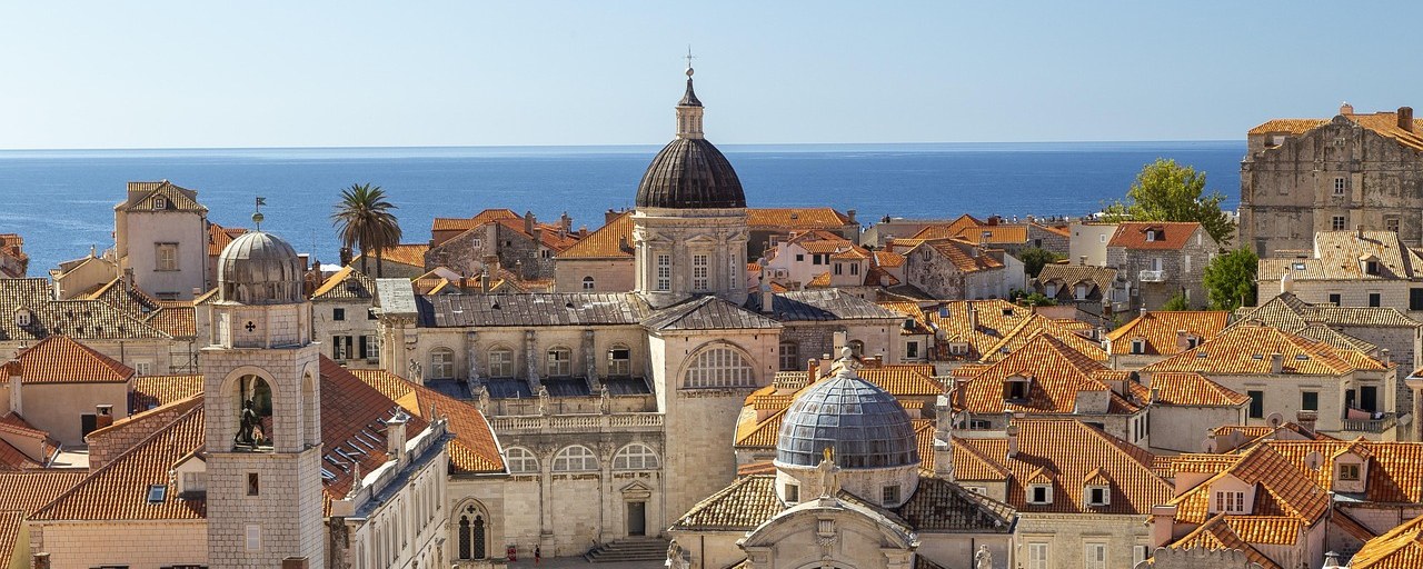 Dubrovnik old town rooftops and cathedral beside the Adriatic Sea in Croatia.