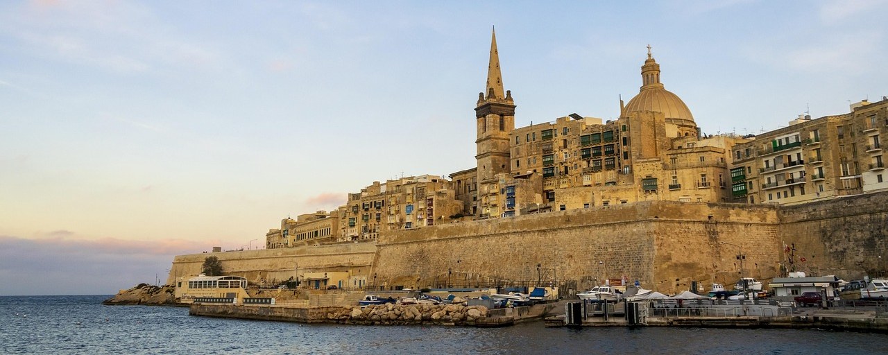 Valletta waterfront with limestone fortifications and church spires, Malta