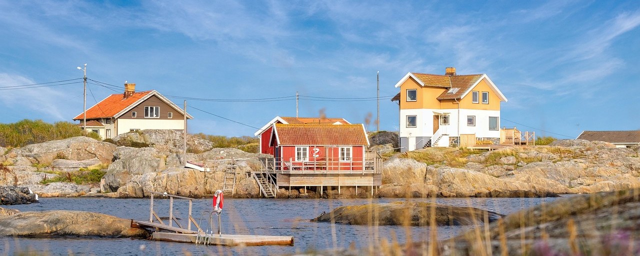 Traditional coastal cottages on the rocky shoreline of Sweden.