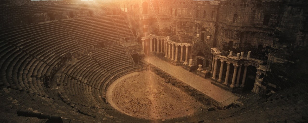 The Roman theatre at Bosra, Syria, in warm evening light.