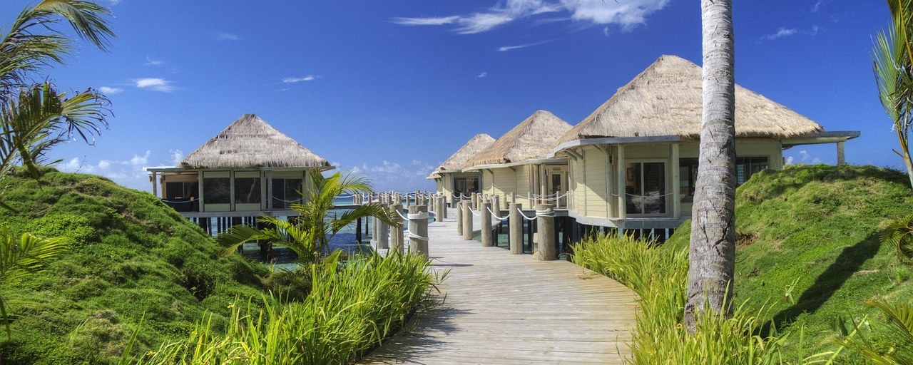 Thatched seaside bungalows and palms in Samoa