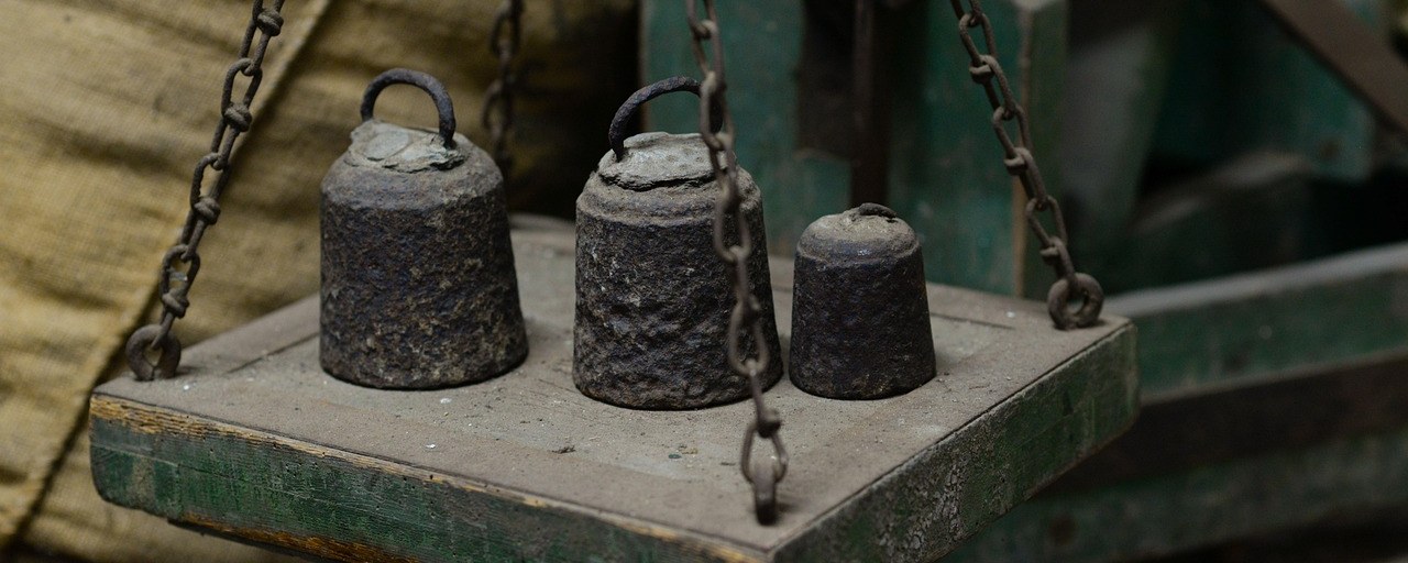 Iron weights on the pan of an old balance scale