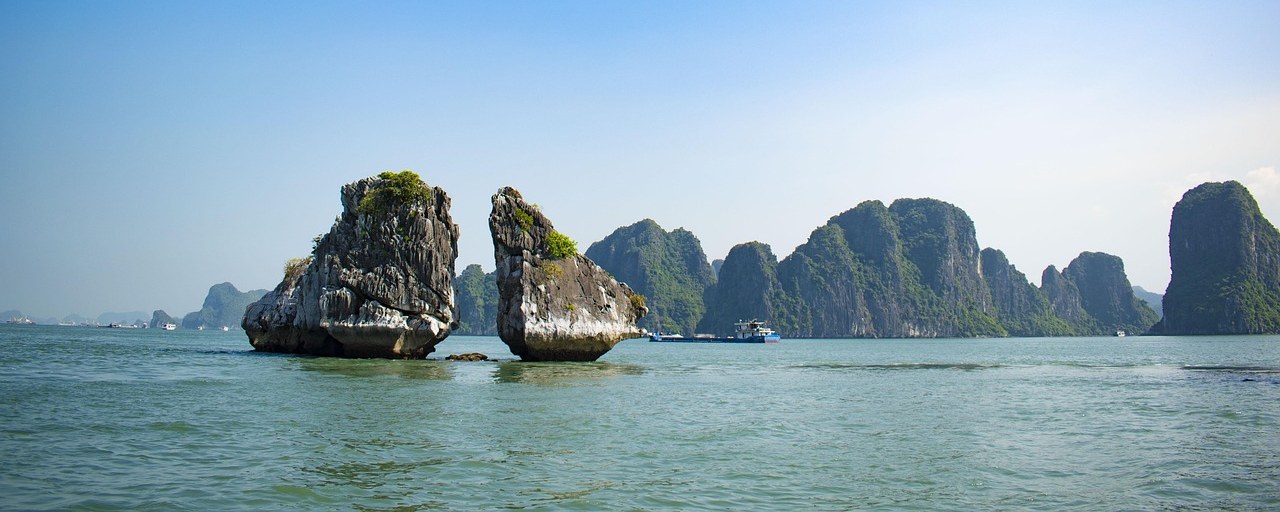 Limestone islands rising from the calm waters of Halong Bay